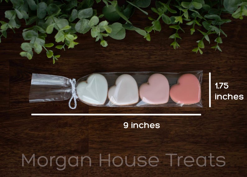 Single cookie sleeve resting on dark wood table with greenery at top of image. Image shows sleeve measures 9 inches long in total and 1.5 inches tall. Morgan House Treats watermark at bottom of image.
