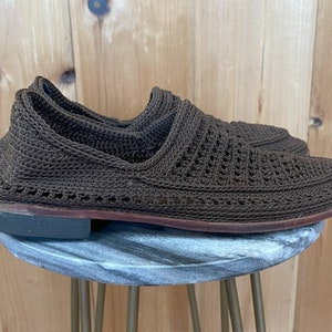 K&ouml;nnte beinhalten: Braune geh&auml;kelte Slipper mit Ledersohle.
