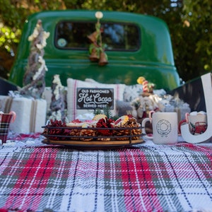 a table with a plaid table cloth and a green truck in the background