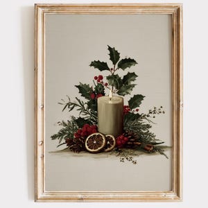 May include: A framed print featuring a lit candle surrounded by holly, red berries, pine cones, and dried orange slices. The candle is beige, and the frame is gold. The overall theme is a vintage Christmas still life.