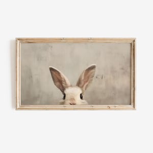 Può includere: Stampa incorniciata raffigurante un coniglio con orecchie lunghe e pelo marrone chiaro. Lo sfondo è grigio chiaro e la cornice è in legno chiaro. Ideale per l'arredamento.