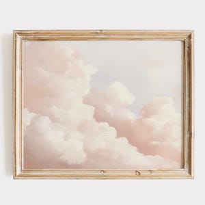 Könnte beinhalten: Ein gerahmtes Gemälde eines rosa und weißen, bewölkten Himmels. Die Wolken sind flauschig und weich, und der Himmel ist hellblau. Das Gemälde ist in einem einfachen Holzrahmen.