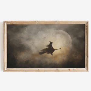 May include: A framed print depicts a witch silhouetted against a full moon, riding a broomstick. The artwork features a dark, moody color palette with a focus on the witch and the moon, creating a spooky Halloween theme.