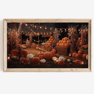 May include: A framed print of a nighttime pumpkin patch scene. The image features various sizes of orange pumpkins, wooden crates, and string lights. The overall color palette is warm, with shades of orange, brown, and yellow.