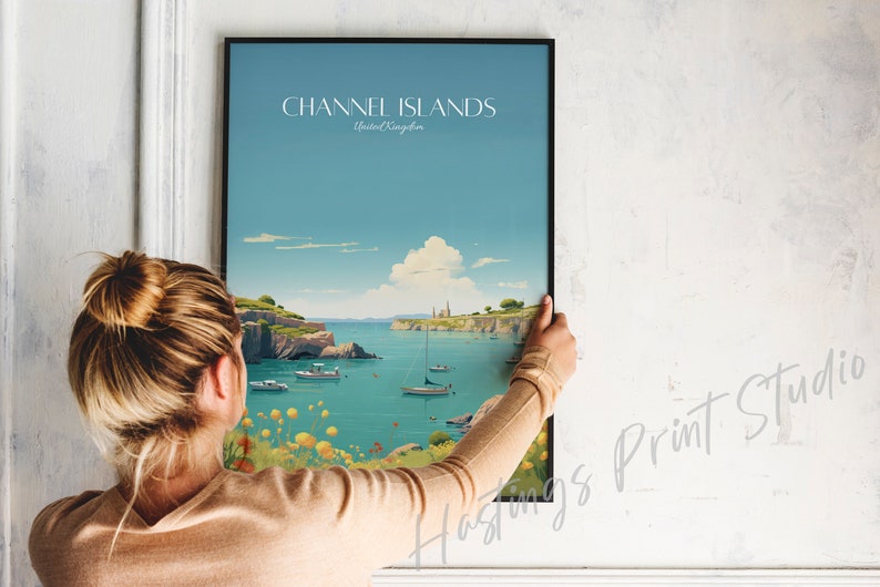 May include: A framed poster with a vintage travel illustration of the Channel Islands, United Kingdom. The poster features a blue sky, a body of water, and a small island with buildings in the distance. The text "CHANNEL ISLANDS" and "United Kingdom" is printed on the poster.