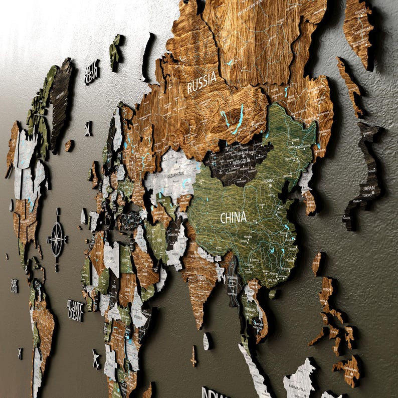 Multi-layered wooden world map with 3 distinct wood heights mounted on a wall.