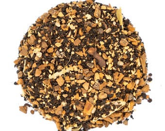 May include: A close-up of a blend of black tea leaves, cinnamon sticks, ginger, cloves, and other spices. The tea is a dark brown color and has a warm, inviting aroma.