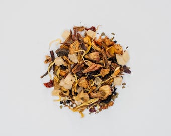 May include: A mix of dried fruit, flowers, and herbs for making tea. The blend includes pieces of dried pineapple, apple, and hibiscus.