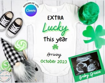 May include: A white onesie with the text "EXTRA Lucky this year" in green and black lettering. The onesie also has a green shamrock and the text "Arriving October 2023". A green and white ultrasound image is in the bottom right corner with the text "Baby Greene".