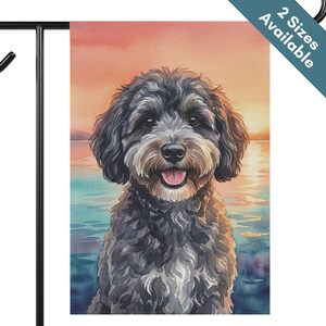 May include: A rectangular garden flag featuring a watercolor illustration of a fluffy black and gray dog with a happy expression. The dog is positioned against a sunset background over water. A blue corner banner displays the text 2 Sizes Available.