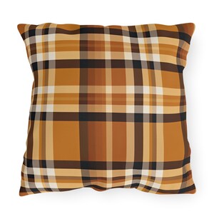 May include: Square throw pillow with a plaid pattern in shades of brown, tan, and black. The pillow has a soft, textured appearance and is designed for decorative use on a couch or bed. The plaid design is a classic pattern.