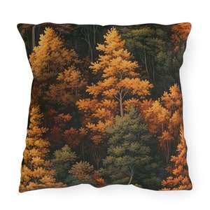May include: Square throw pillow featuring a forest scene with trees in shades of gold, brown, and green. The pillow has a dark background, creating a contrast with the colorful foliage. The design evokes a sense of nature and the outdoors.