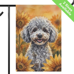May include: A rectangular garden flag featuring a watercolor-style illustration of a curly-haired gray dog centered among vibrant yellow sunflowers against an orange and yellow background. The top right corner includes a green diagonal banner with the text 2 Sizes Available.