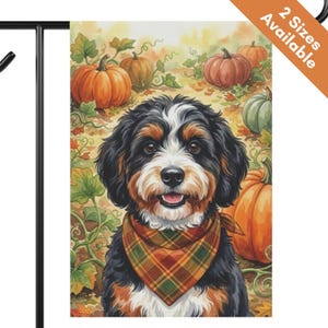 May include: A rectangular garden flag featuring a watercolor illustration of a Bernese Mountain Dog wearing a plaid bandana. The dog is centered against a background of orange pumpkins and green vines. The top corner includes orange text 2 Sizes Available.