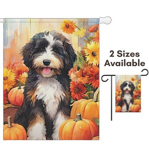 May include: A decorative garden flag featuring a watercolor illustration of a Bernedoodle dog surrounded by pumpkins and fall foliage. The flag has a white pole sleeve and the text "2 Sizes Available".