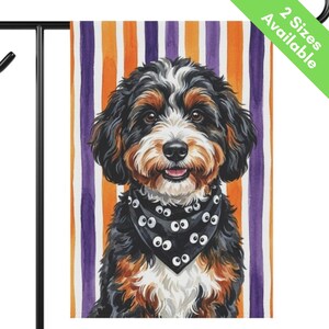 May include: A rectangular garden flag featuring a tri-color Bernedoodle dog with black, white, and brown fur. The dog wears a black bandana patterned with white cartoon eyes. The background consists of vertical orange and purple stripes.