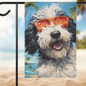 May include: A black and white dog wearing orange sunglasses is pictured in front of a beach scene with palm trees. The dog is smiling and has a happy expression.