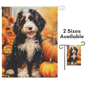 May include: A garden flag featuring a watercolor painting of a Bernedoodle dog with black, white, and brown fur, sitting among pumpkins and sunflowers. The flag has a white pole sleeve and the text "2 Sizes Available".