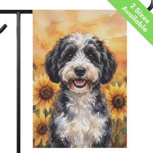 May include: A rectangular garden flag featuring a watercolor illustration of a black and white dog with floppy ears, positioned in front of bright yellow sunflowers against a warm orange and yellow background. The text 2 Sizes Available appears.