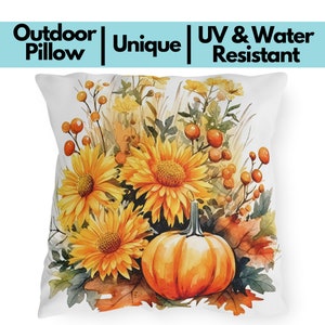 May include: White outdoor pillow with a watercolor design featuring large yellow sunflowers, an orange pumpkin, and fall foliage. The pillow has the text "Outdoor Pillow | Unique | UV & Water Resistant".