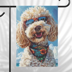 May include: A white poodle with curly hair wearing red sunglasses and a colorful bandana with a tropical print. The dog is smiling and looking to the right. The background is a blue sky with white clouds.