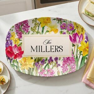 May include: An oval serving platter with a floral design featuring tulips, daffodils, and other spring flowers. The center of the platter has the text "The MILLERS" in a decorative font.