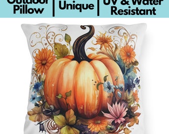 May include: White outdoor pillow with a watercolor design featuring a large orange pumpkin surrounded by orange, blue, and pink flowers. The pillow has the text "Outdoor Pillow | Unique | UV & Water Resistant".