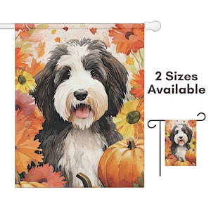 May include: A garden flag featuring a watercolor illustration of a black and white dog with a pumpkin and fall flowers. The flag has a white pole sleeve and the text "2 Sizes Available".
