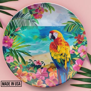 May include: A colorful ceramic plate with a tropical design featuring a parrot, palm leaves, and hibiscus flowers. The plate has a blue and green ocean scene in the background.