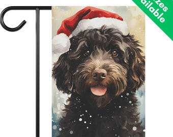May include: A garden flag featuring a watercolor illustration of a black dog wearing a red Santa hat with white trim. The dog has brown eyes and a pink tongue. The flag is mounted on a black metal stand.