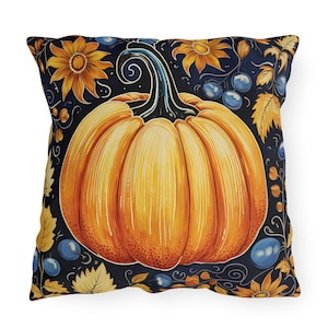 May include: Square decorative pillow featuring a large orange pumpkin with a dark blue background. The pumpkin is surrounded by yellow sunflowers, blue berries, and autumn leaves. The pillow has a white background.