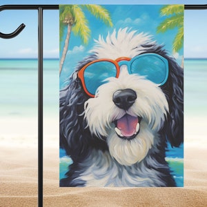 May include: A rectangular garden flag featuring a painting of a black and white dog with a fluffy coat, wearing bright orange and blue sunglasses. The dog has an open mouth with a visible tongue, set against a backdrop of palm trees and a blue sky.