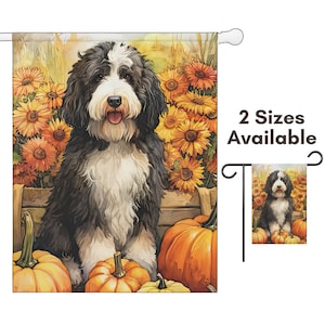 May include: A garden flag featuring a black and white dog with a pumpkin and sunflower background. The flag has the text "2 Sizes Available". The dog is sitting in front of orange pumpkins and yellow sunflowers.