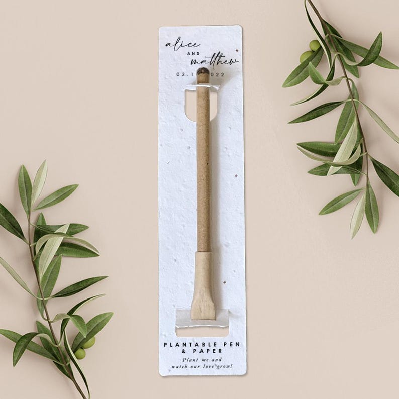 May include: A plantable pen and paper set. The pen is made of light brown material and is packaged on a white card with the names "alice and matthew" and the date "03.1 022". The card also includes the text "Plant me and watch our love grow!"