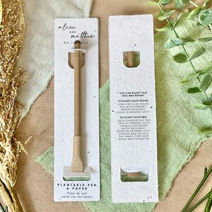 May include: A plantable pen and paper set with the names "alice and matthew" and the date "03.1 022" printed on the packaging. The pen is made of light brown wood. The packaging includes instructions for planting.