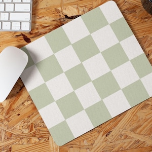 Puede incluir: Una alfombrilla de ratón a cuadros verde y blanco sobre una superficie de madera.