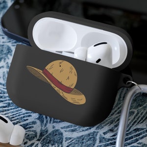 May include: Black Airpods case with a cartoon image of a straw hat. The case has a silver carabiner attached.