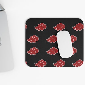 Puede incluir: Una alfombrilla de ratón negra con un patrón repetitivo de nubes rojas sobre un fondo negro. Un ratón de ordenador blanco está sobre la alfombrilla de ratón.