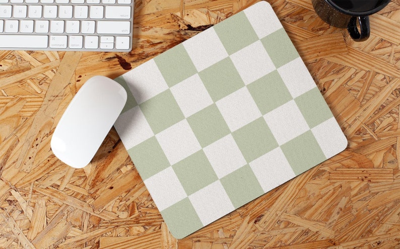 Peut inclure: Un tapis de souris &agrave; carreaux verts et blancs sur une surface en bois.