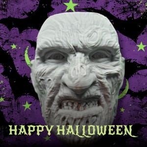 May include: A white, 3D printed Halloween mask of a monster with a grotesque expression. The mask has a wrinkled forehead, a large nose, and a wide, open mouth with visible teeth. The background is a purple and green pattern with bats and stars.