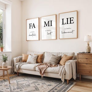 Familie Poster Set 3-teilig mit moderner Typografie in Schwarz-Weiß, eingerahmt in Holzrahmen.