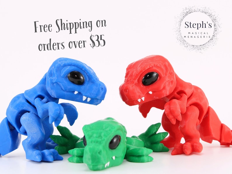 May include: Three articulated dinosaur figurines in blue, red, and green are displayed against a white background. The blue and red dinosaurs stand upright, while the green one lies flat. The image includes the text "Steph's Magical Menagerie."