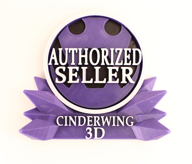 May include: A 3D-printed badge in shades of purple, black, and white. The badge reads "AUTHORIZED SELLER" in bold white letters, with "CINDERWING 3D" below. The design features a circular emblem and a starburst-like base.