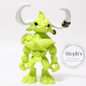May include: A lime green figurine of a bull-like creature with large white horns and a stern expression. The figure has a muscular build and is wearing a belt and shoulder armor. The figure is approximately 5 inches tall.