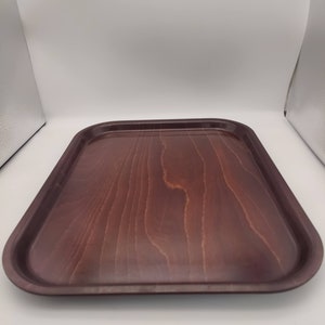 May include: A rectangular wooden serving tray with a dark brown finish. The tray has rounded corners and a smooth surface with visible wood grain. The tray is empty and sits on a white background.