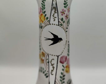Könnte beinhalten: Eine klare Glasvase mit rosafarbenem Rand und bemalten Blumendesigns. Die Vase zeigt eine schwarze Silhouette eines Vogels in einem Kreis mit gepunktetem Rand.