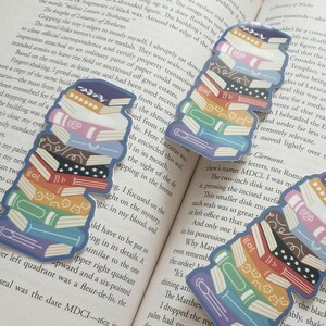 Puede incluir: Una pila de libros coloridos con diferentes dise&ntilde;os y patrones. Los libros est&aacute;n apilados uno encima del otro, creando una torre de libros. Los libros son de diferentes tama&ntilde;os y formas, y todos est&aacute;n cerrados.