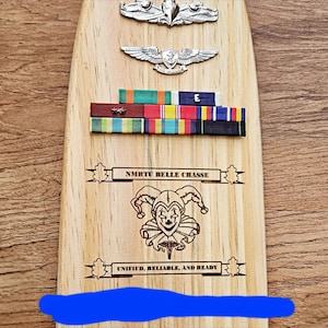 Military paddle with ribbons and devices