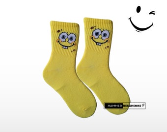 Strahlendes Gelb: Die Sponge-Socken, die immer lächeln.  Gelbe Socken mit Smiley-Humor und ein ein Lächeln den ganzen Tag. Gute Laune Socken