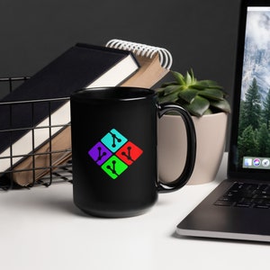 Puede incluir: Taza de cerámica negra con un logotipo colorido que presenta cuatro nodos conectados en forma de diamante. El logotipo está en tonos de azul, morado, verde y rojo.